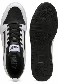 Sorte og hvide sneakers med en glat læderoverdel, perforerede detaljer og en tekstureret gummisål med logo accenter.