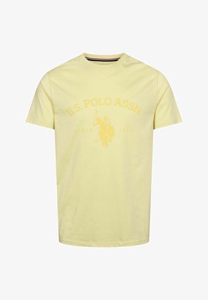 Geltonas medvilninis marškinėlis su apvaliu kaklu, trumpomis rankovėmis ir centrine grafika, vaizduojančia polo žaidėją su užrašu "U.S. POLO ASSN. SINCE 1890".