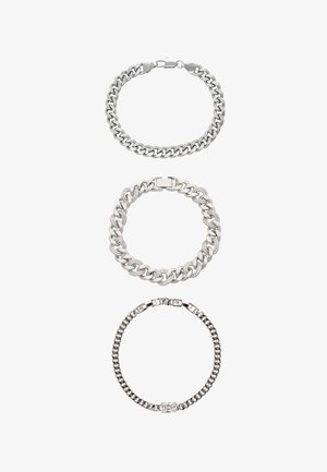 Tre braccialetti d'argento disposti verticalmente, con vari design a catena e un braccialetto centrale con un particolare rettangolare trasparente.