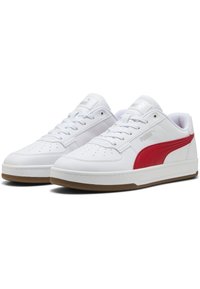 Hvide sneakers med røde sidelister og polstrede kraver. Lavet af læder med en struktureret overflade og såler i gummigummi. Har perforeringer for åndbarhed.