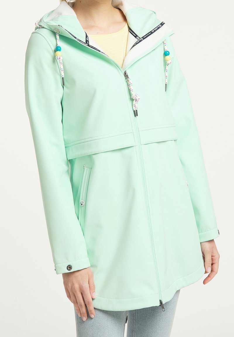 Veste imperméable vert menthe avec fermeture éclair à l'avant, capuche ajustable et accents décoratifs en corde. Elle possède deux poches latérales et une coupe décontractée.