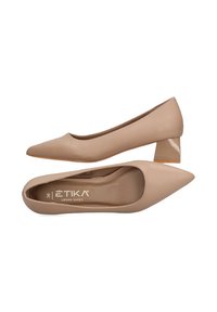 Zapatos de tacón destalonado de imitación piel en tono nude con un tacón bajo. Textura suave y marca mínima visible en la plantilla.