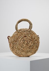 Borsa rotonda in paglia intrecciata con design a spirale, dettagli in pelle e doppio manico. Colore beige naturale con finitura testurizzata.