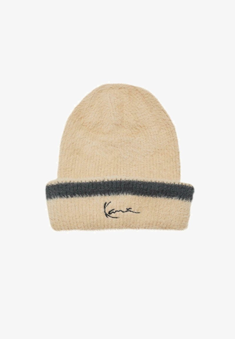 Beige kötött sapka hajtott széllel, sötétszürke csíkkal és fekete hímzett logóval. Puha anyag, bolyhos textúrával.