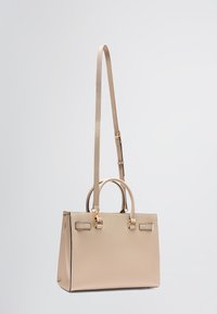 Sac à main en cuir beige avec doubles poignées, une bandoulière amovible, quincaillerie dorée et finition texturée. Forme rectangulaire avec un minimum de détails.