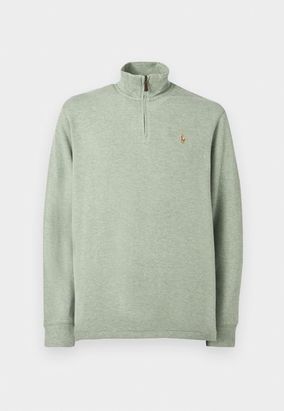 Φωτεινό πράσινο πουλόβερ με μισό φερμουάρ και γιακά, μακριά μανίκια και κεντημένο λογότυπο στο στήθος. Φτιαγμένο από μαλακό, υφασμάτινο υλικό.