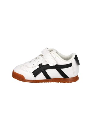 Zapatilla deportiva infantil blanca con franjas laterales negras, suela marrón, cordones y una cierre de velcro sobre fondo blanco.