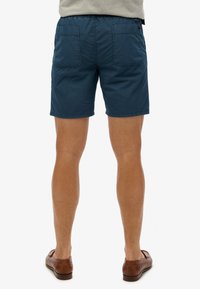 Shorts bleu marine en tissu léger, dotés d'une taille élastique, de deux poches arrière et d'une coupe décontractée au-dessus du genou.