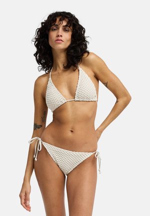 Set bikini all'uncinetto in crema, con top triangolare con lacci e slip regolabile con fiocchi laterali, caratterizzato da motivi texture.