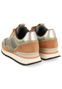 Zapatillas con una mezcla de ante naranja, tela oliva y acentos plateados. Suela gruesa blanca y rosa; forro de malla gris y cordones marrones.
