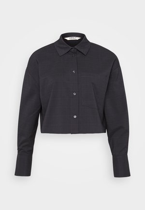 Afskåret sort ternet skjorte lavet af vævet stof, med knaplukning foran, lange ærmer og en brystlomme.