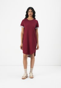 Burgundy t-paita mekko, jossa on lyhyet harmaat hihat, rento istuvuus, polvenpituinen, sivuaukot, valmistettu pehmeästä puuvillakankaasta.