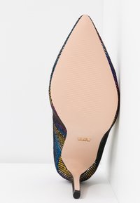 Chaussure à talon haut à bout pointu avec empeigne en maille multicolore et semelle beige lisse équipée d'un petit embout de talon noir.