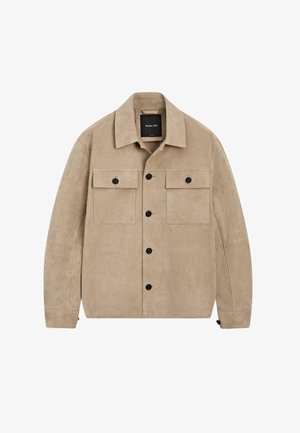 Beżowa zamszowa koszula-narzutka z rozłożystym kołnierzem, zapięciem na guziki, dwoma kieszeniami na piersi z klapkami na guziki oraz długimi rękawami.