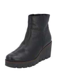 Botte de cheville en cuir noir avec un talon compensé, présentant une texture lisse, un bout arrondi et une fermeture éclair sur le côté.