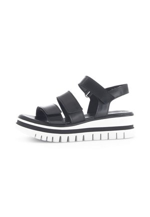 Black leather sandals with three adjustable straps, a cushioned footbed, and white ridged platform sole accented by a black stripe.
