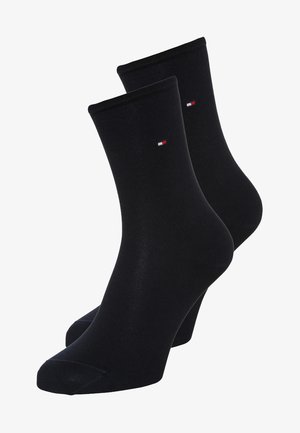 Black cotton ankle socks with a ribbed cuff, featuring a small red, white, and blue logo at the top. Smooth texture, standard fit.