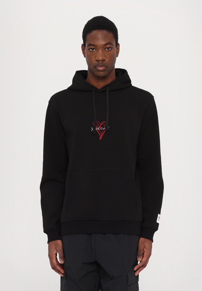 Hoodie noir avec une poche frontale, capuche à cordon de serrage et un logo de cœur rouge brodé sur la poitrine. Présente des poignets et un ourlet côtelés.