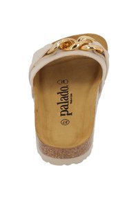 Krämfärgad slide sandal med korksula, med en guldkedjeaccent över ovandelen och en mjuk innerfoder. Varumärkeslogotyp synlig inuti.