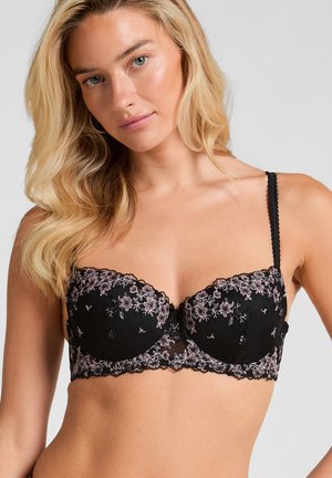 Zwarte kanten beha met bloemenborduursel in tinten roze, een golfrand en verstelbare bandjes voor een perfecte pasvorm.