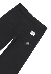 Jeans in denim neri con un classico design a cinque tasche, caratterizzati da un distintivo dettaglio a tasca posteriore triangolare e un'etichetta tessuta sulla cintura.