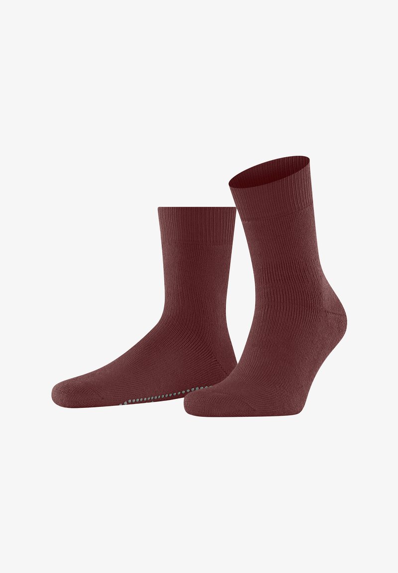 Une paire de chaussettes côtelées rouge foncé avec des grips antidérapants sur la semelle, présentée sur un fond blanc.