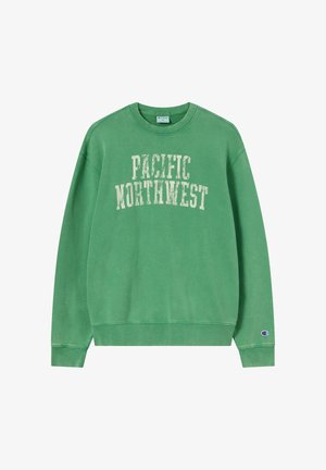 Grüner Sweatshirt mit Rundhalsausschnitt, auf der Brust "PACIFIC NORTHWEST" in weißer, abgenutzter Schrift und kleinem Champion-Logo am linken Ärmelbündchen.