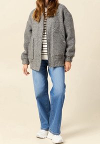 Gray woolen bomber jacket with two front pockets, ribbed cuffs, and bottom hem, worn over a black and white striped top and blue jeans.