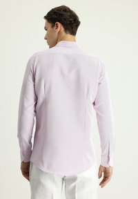Camisa de manga larga de color púrpura claro con tejido texturizado, cuello clásico y puños con botón, que presenta un dobladillo curvado y un diseño de ajuste slim.