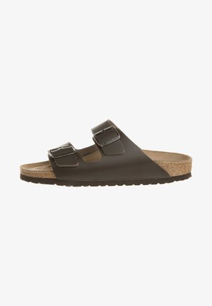 Bruine sandaal met twee banden, bevat een kurken voetbed, textuur van synthetisch materiaal bovenkant, en verstelbare metalen gespen. Vlakke zool voor comfort.