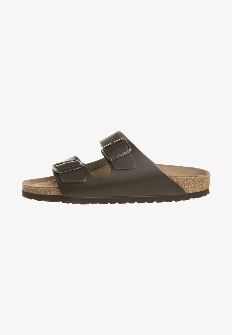 Sandal marrone a due cinturini con fondo in sughero, upper sintetico texturizzato e fibbie in metallo regolabili. Suola piatta per il massimo comfort.