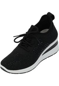 Svart sportskor med ett stickat överdel som har ett strukturerat mönster, snörningsdesign och en kontrasterande vit och svart kil-sula.