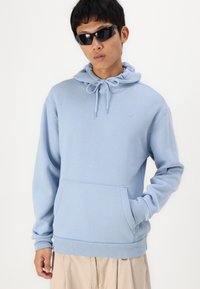 Helleblaue Kapuzenjacke mit Kordelzug, Kängurutasche und gerippten Bündchen. Weiches Material mit minimalistischem Design.