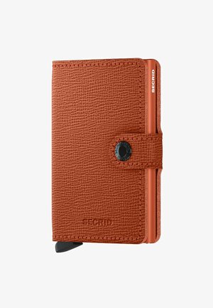 Orange leather wallet with textured finish, button closure, and metal accents. Features a card holder extending from the side. Brand embossed.