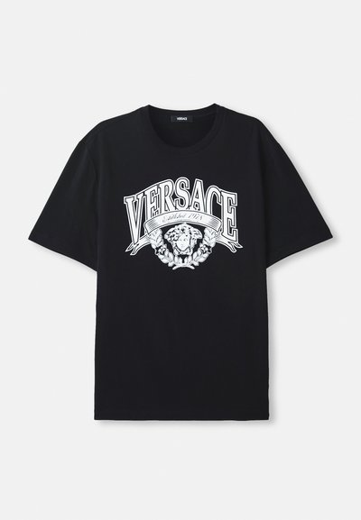 Juodas medvilninis marškinėlis, ant kurio yra didelis baltas grafikas su užrašu "VERSACE" ir menine veido dizaino ornamentika, apsupta lapų.