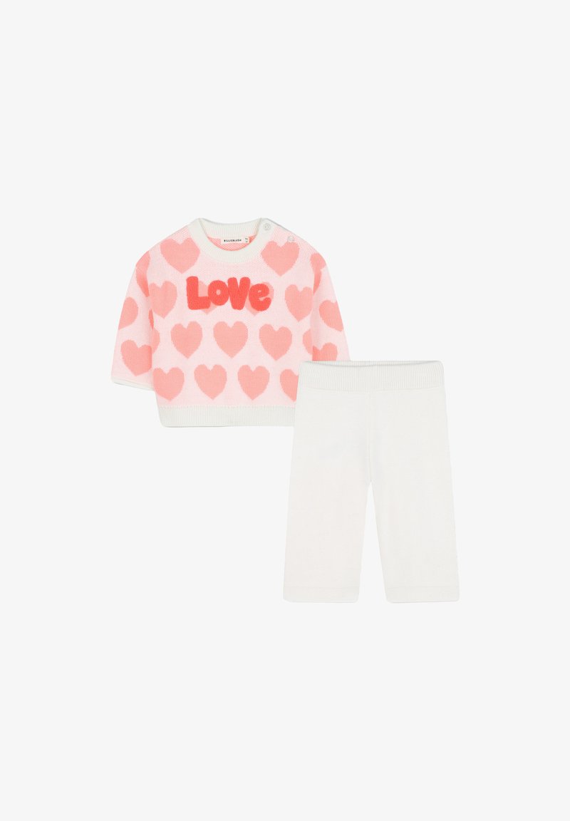 Gehaakte tweedelige outfit met een roze trui met korte mouwen, versierd met hartpatronen en de tekst "Love", gecombineerd met witte leggings.