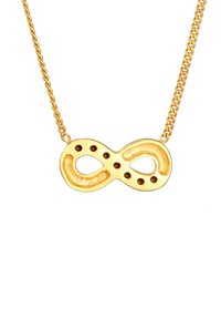 Goldenes Unendlichkeitshalsband mit einer strukturierten, glatten Oberfläche, das ausgeschnittene Details und kleine Löcher im Design aufweist, aufgehängt an einer Kette.