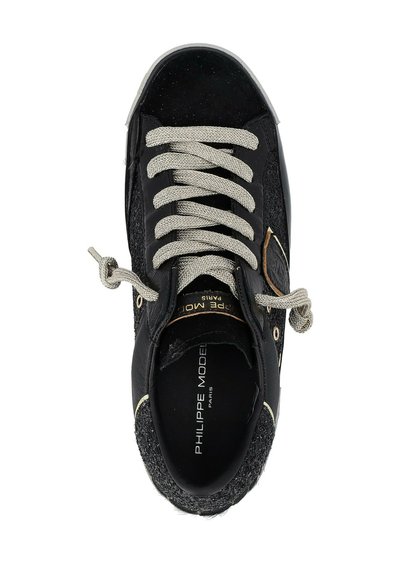 Sneaker nera con lati texturizzati, lacci beige annodati e branding "Philippe Model Paris" all'interno della soletta e dell'etichetta sulla linguetta.