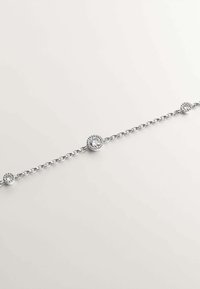 Pulsera de plata con acentos de piedras redondas, que presenta un diseño de cadena delicada y tres detalles circulares espaciados uniformemente, cada uno engastado con un cristal transparente.