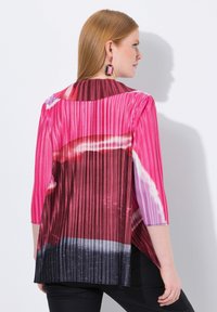 Blusa plissettata in un vivace rosa, bordeaux e nero. Caratterizzata da maniche a tre quarti e da un collo alto, con un design leggero e fluente.
