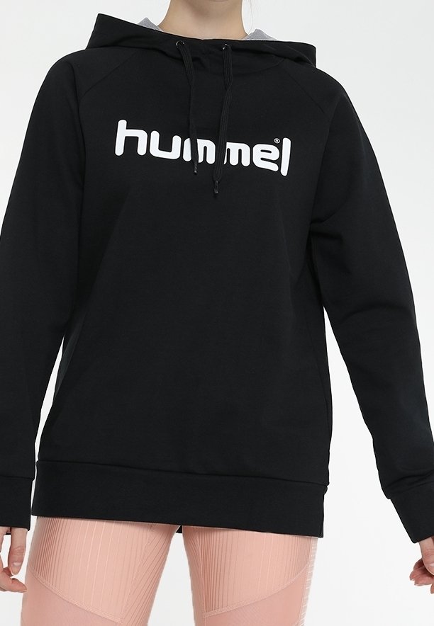Svart huvtröja med en gråfodrad huva, har en stor vit "hummel"-logotyp på framsidan. Tillverkad av ett mjukt tyg, designad med en avslappnad passform.