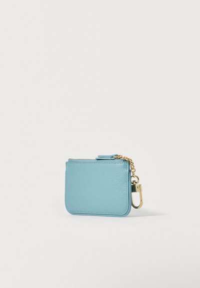 Μικρό ανοιχτό μπλε δερμάτινο πορτοφολάκι με φερμουάρ, χρυσή αλυσίδα και κρίκο κλειδιών σε λευκό φόντο.