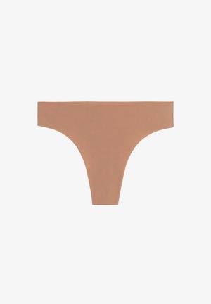 Stringi w kolorze nude wykonane z gładkiej, elastycznej tkaniny. Posiadają nisko osadzony kraj oraz minimalne krycie bez widocznych szwów.