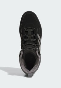 Zapatilla alta negra con upper texturizado, acentos grises, perforaciones en la puntera y un forro suave para mayor comodidad.