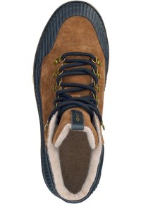 Braune Wildleder-Stiefelette mit schwarzen Gummielementen, ausgestattet mit Messing-Ösen, dunklen Schnürsenkeln und einem weichen, mit Fell gefütterten Innenraum für Wärme.