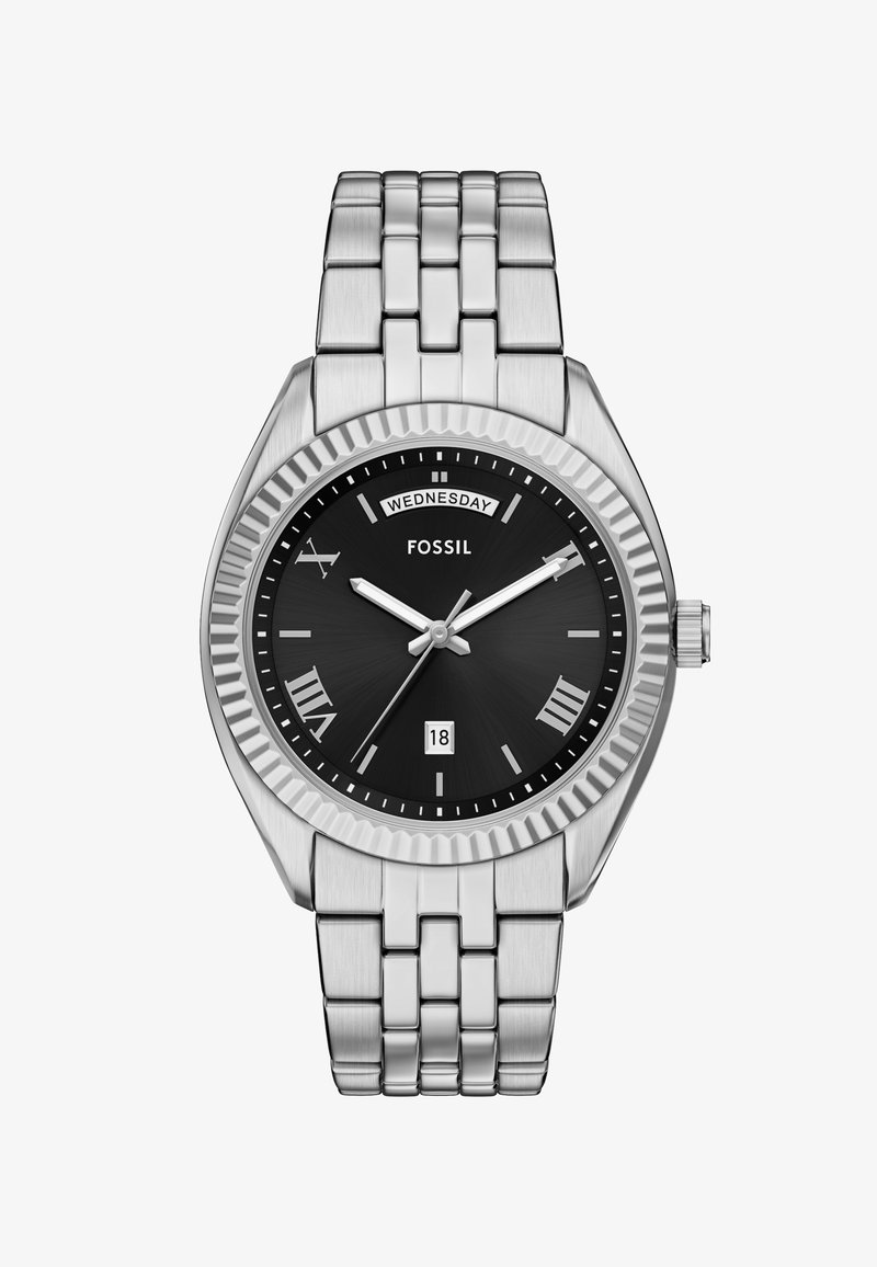 Montre en acier inoxydable argenté avec un cadran noir, des index en chiffres romains, un affichage de la date et une lunette texturée. Elle possède un bracelet en métal maillon.