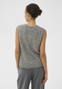 Harmaa ilmanhihaiset neulepaita, jossa on teksturoitu kuvio, pyöreä pääntie ja hillitty helma, yhdistettynä raitapö trousers.