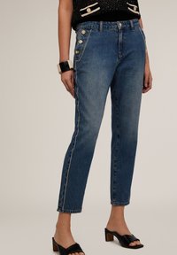 High-waisted blauwe denim jeans met een rechte snit, voorzien van zijknopen, contrasterende stiksels en een subtiel uitgerafelde zoom.