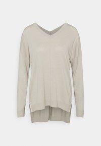 Pull beige clair à manches longues avec col en V, coupe ample et ourlet arrière légèrement plus long.