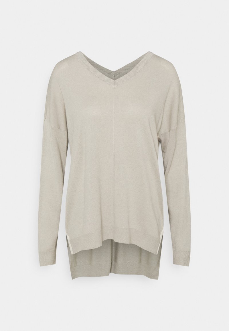Pull beige clair à manches longues avec col en V, coupe ample et ourlet arrière légèrement plus long.